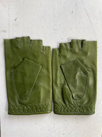 The "Ines Vintage - Fingerless Fashion Leather Driving Gloves" by Ines Gloves are displayed on a white surface. This pair of stylish green leather gloves features quilted stitching along the bottom edge and extra padding on the palms. Both gloves have small openings for the fingers and appear to be in excellent condition.